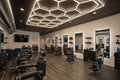 Barber shop interior with chairs and mirrors, modern ceiling design.